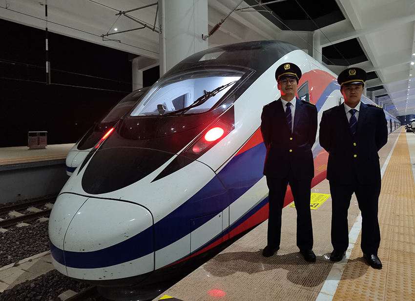 劉銀能（右一）與中國師父鄔俊鴻在動(dòng)車組前合影。受訪者供圖