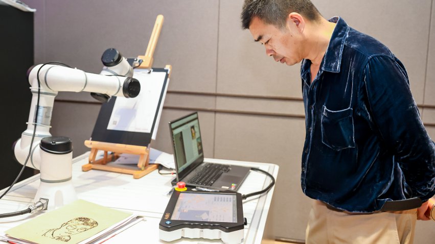 嘉賓體驗(yàn)遨博AI繪畫機(jī)器人。主辦方供圖